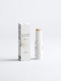 A white cosmetic stick and its matching white box with black text, photographed on a clean light gray studio background. The product appears to be a ceramide balm stick with SPF 30.
